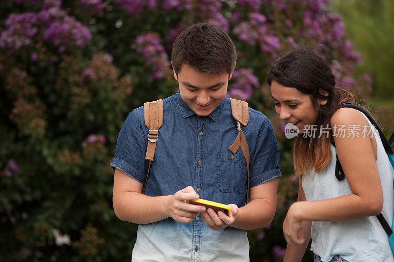 两个高中生在看智能手机