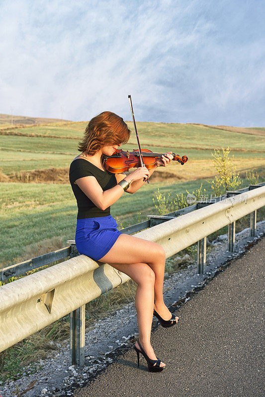 在高速公路上拉小提琴的女人