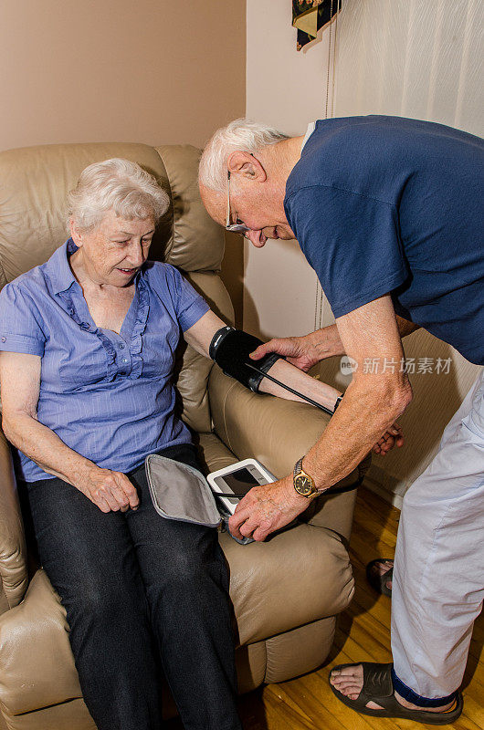 一位老人正在给他的妻子量血压