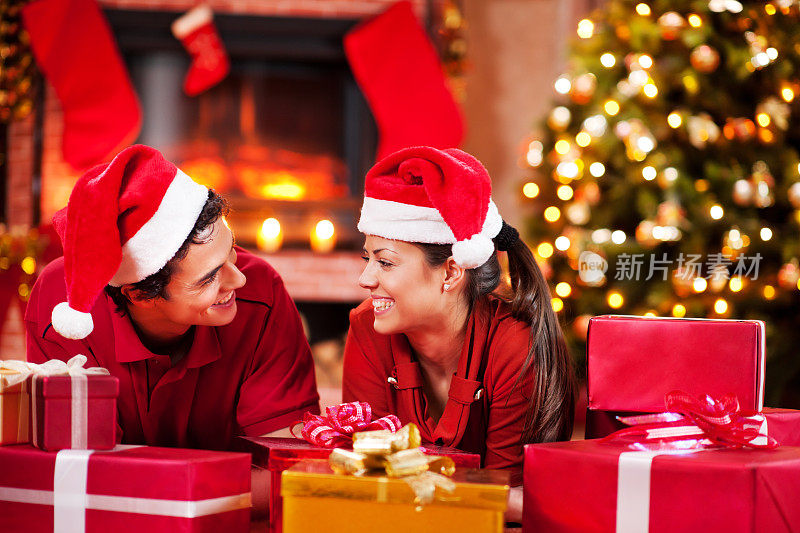 欢乐的情侣躺在一组圣诞礼物。