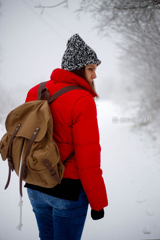 女徒步旅行者背包和雪鞋在雪地上的雪鞋