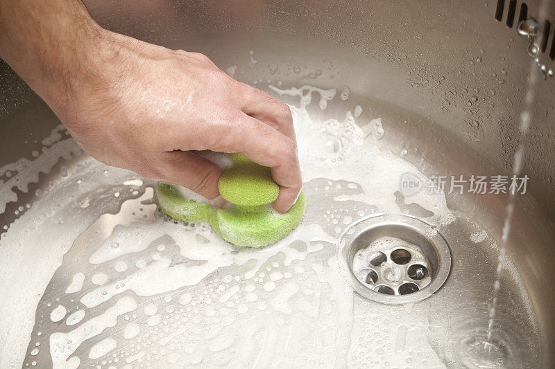 用擦水垫擦洗厨房水槽。