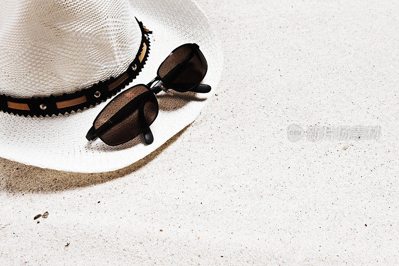 在海滩上戴着帽子和太阳镜