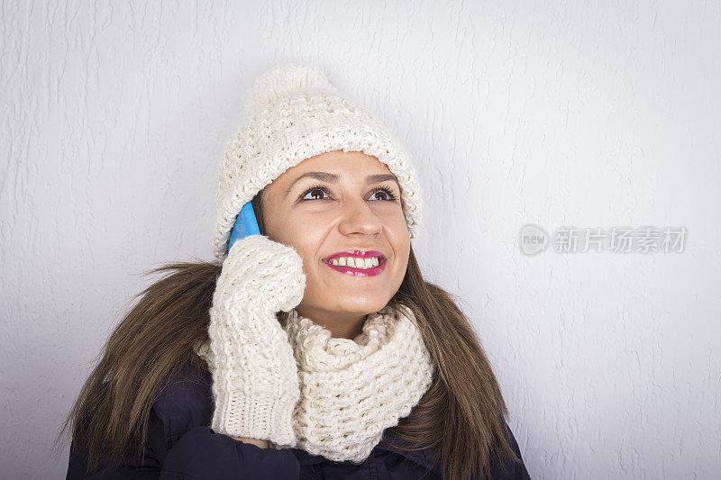 微笑的女人在针织冬季服装说话移动