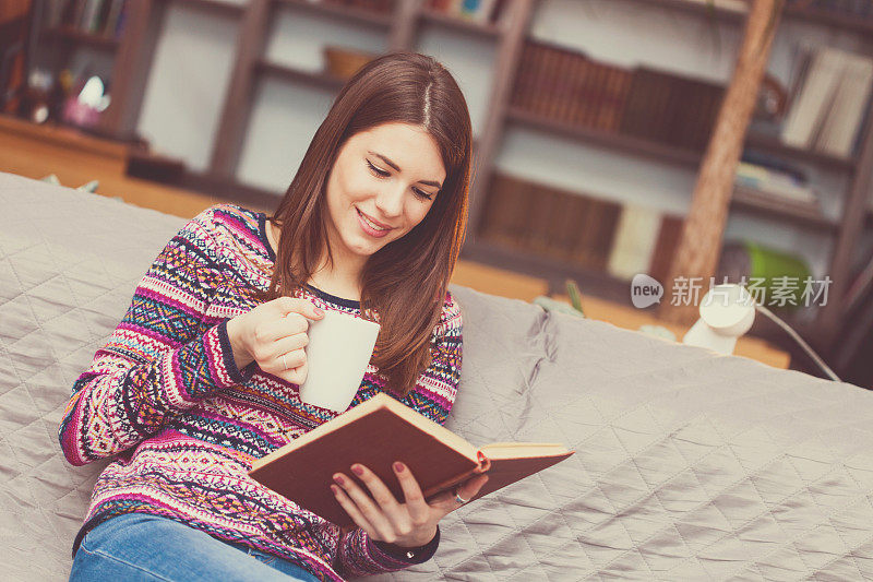 女人一边看书一边喝咖啡
