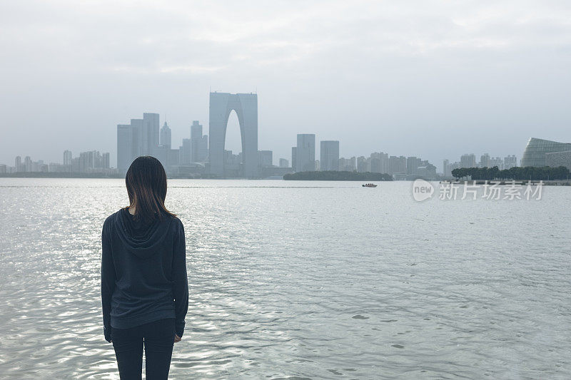 后视图的女人站在湖边看美丽的风景