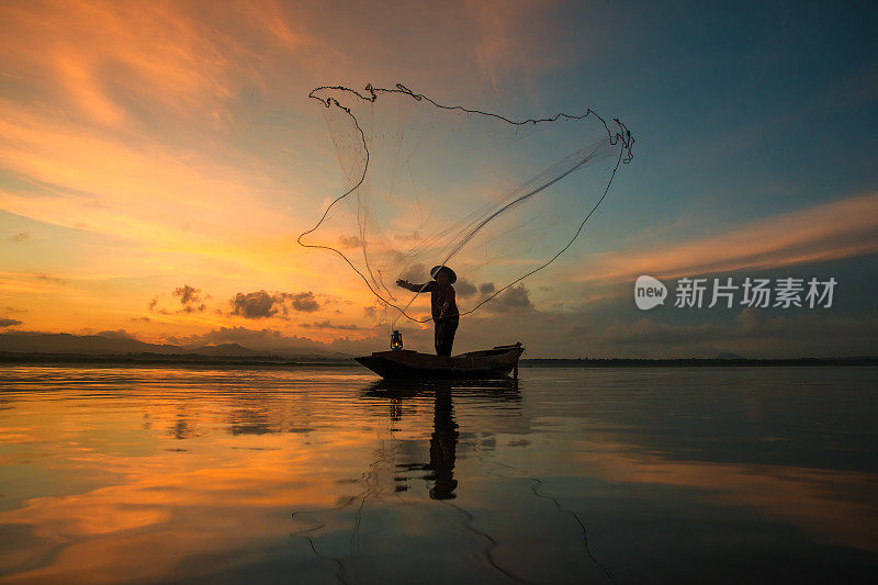 清晨，泰国渔夫在湖边钓鱼。