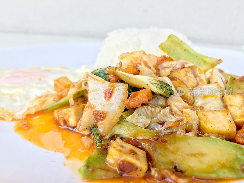 自制小豆腐炒，蔬菜辣椒酱拌饭和炒鸡蛋在白色的背景上庆祝春节。健康素食食品。泰国的风格。