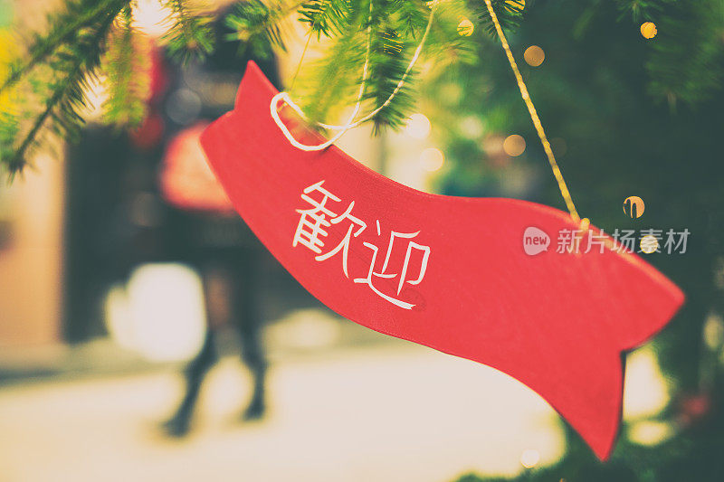 克拉科夫的圣诞树上有一块牌子，上面写着欢迎的字样，翻译成日本语