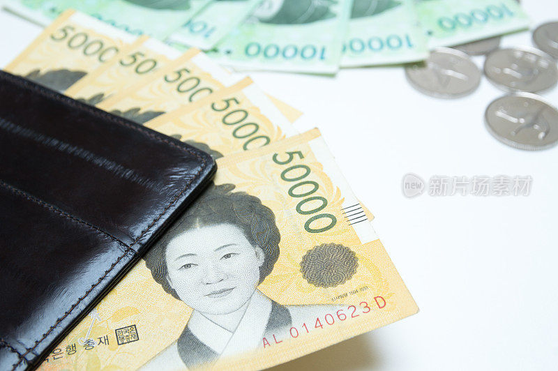 不同价值的韩元在钱包附近的白色背景上