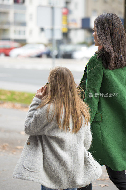 一个女人和一个拿着智能手机的小女孩