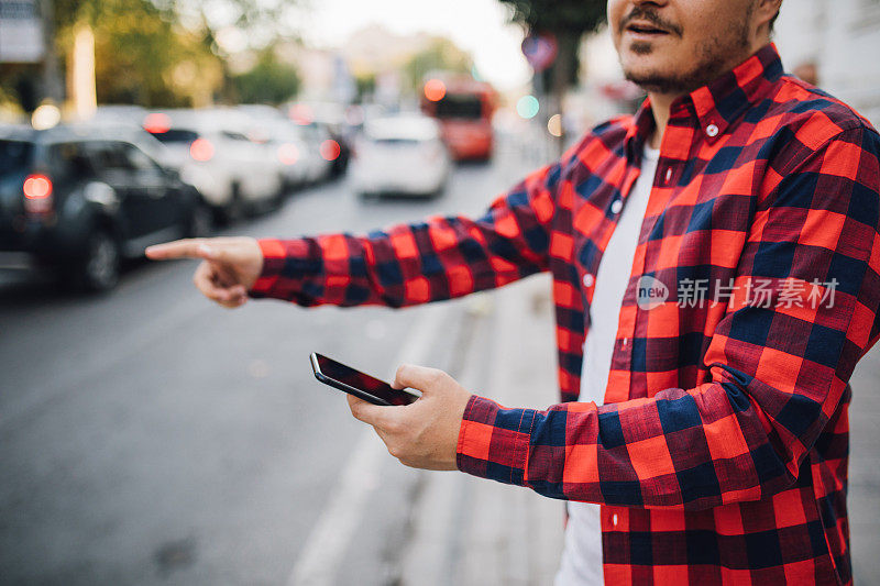 一名男子在城市街道上叫出租车