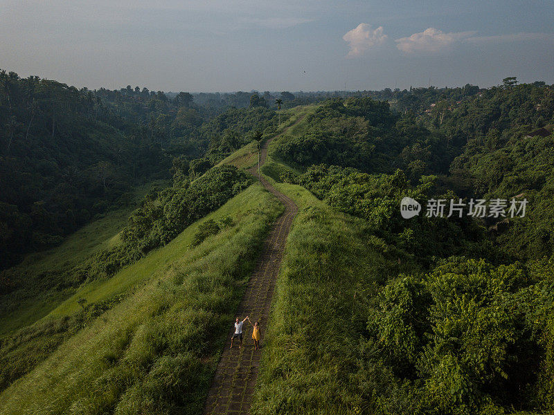 无人机的观点，年轻夫妇走在大米自然散步，乌布-巴厘岛-人们旅游热带目的地爱浪漫的概念