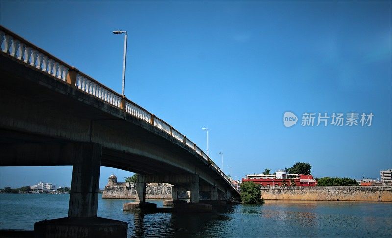 卡塔赫纳第25街桥横跨圣拉萨罗泻湖，桥的另一边有历史悠久的防御墙环绕着格塞马尼城区。