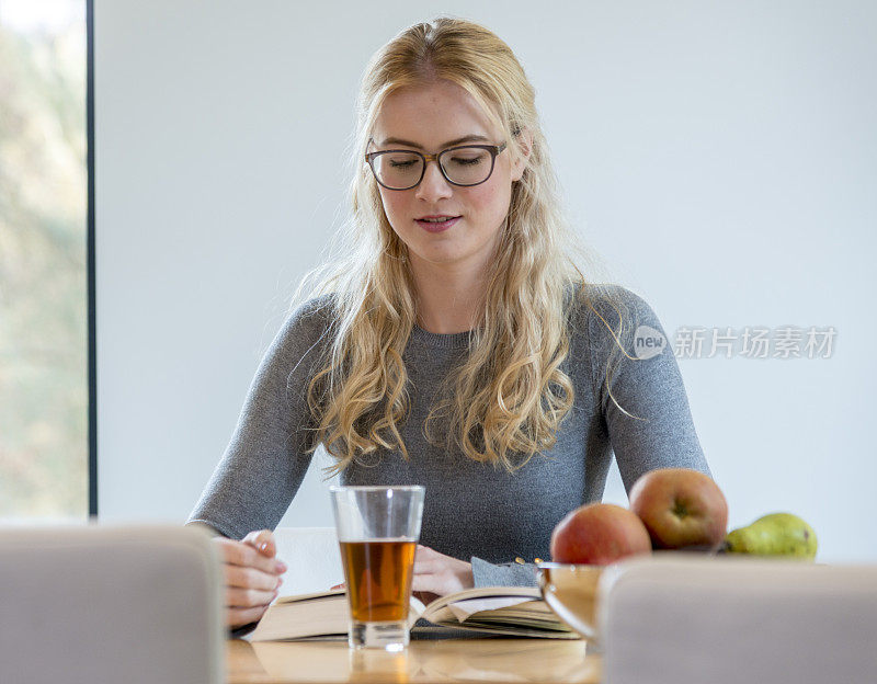 女孩喝着热茶读着书