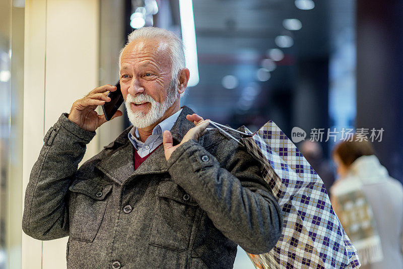 在购物中心使用智能手机的老年人