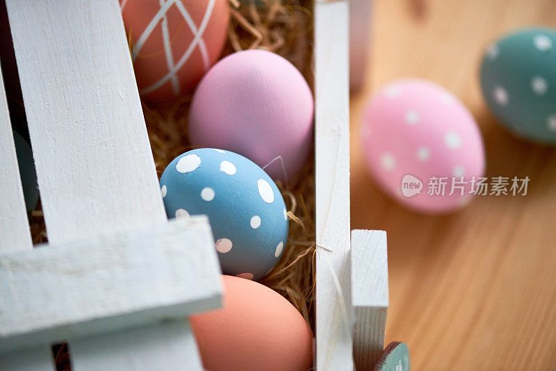 多色复活节彩蛋的特写放在餐桌上的木箱干草中