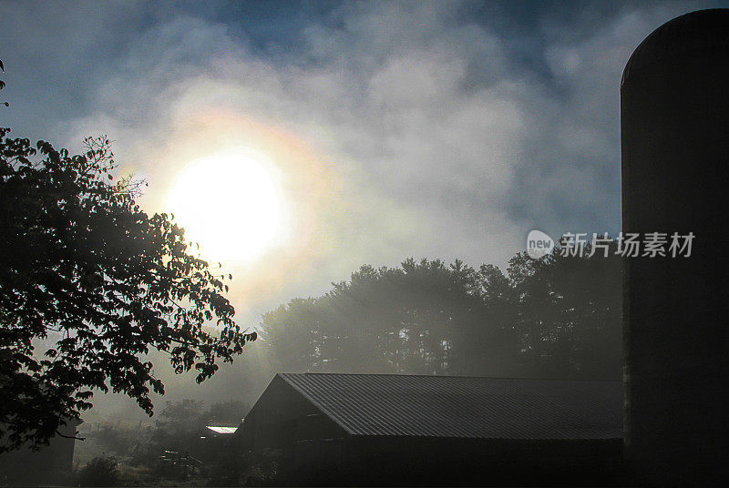 太阳冲破迷雾，从农场上空升起