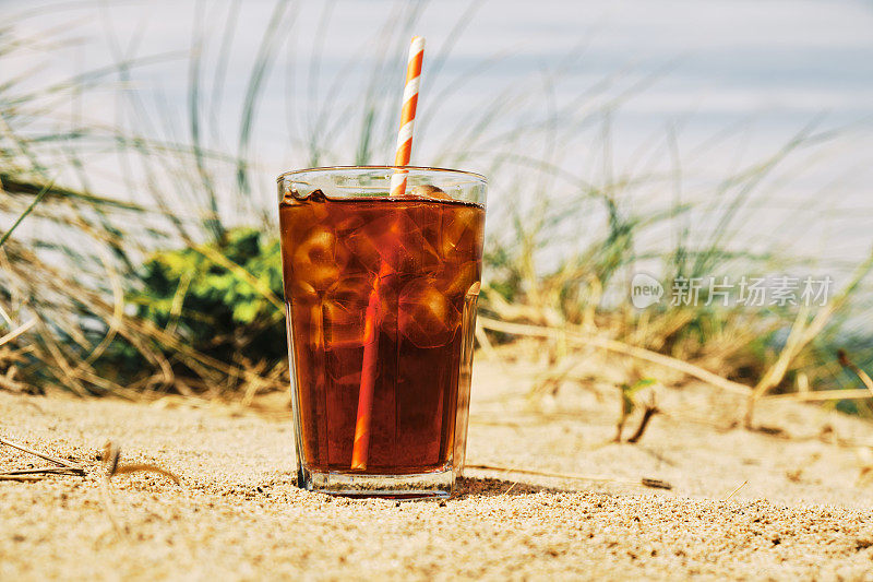 在一个炎热阳光明媚的夏日，在纽基菲斯特拉海滩的沙丘上喝一杯冰黑咖啡。