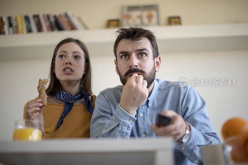 一对年轻夫妇在看足球比赛并庆祝