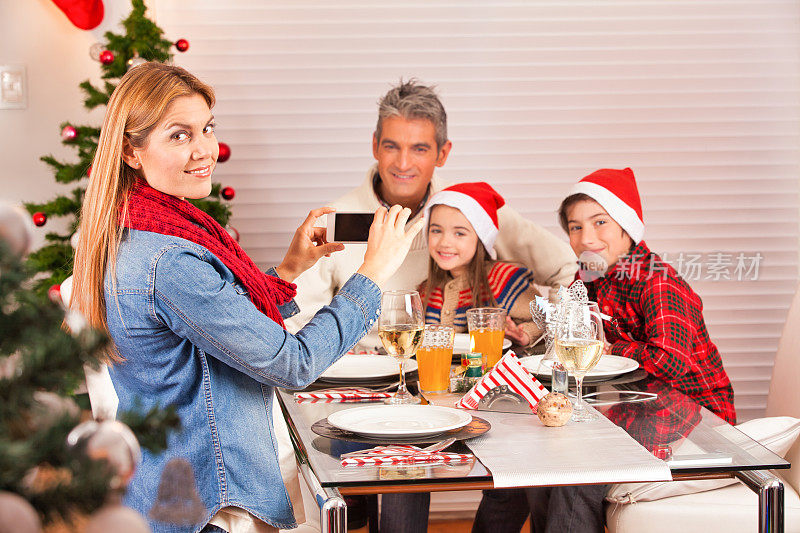 人们拥有现代科技。快乐的一家人在圣诞晚餐之夜自拍