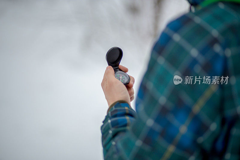 这个人看着雪山背景上的指南针