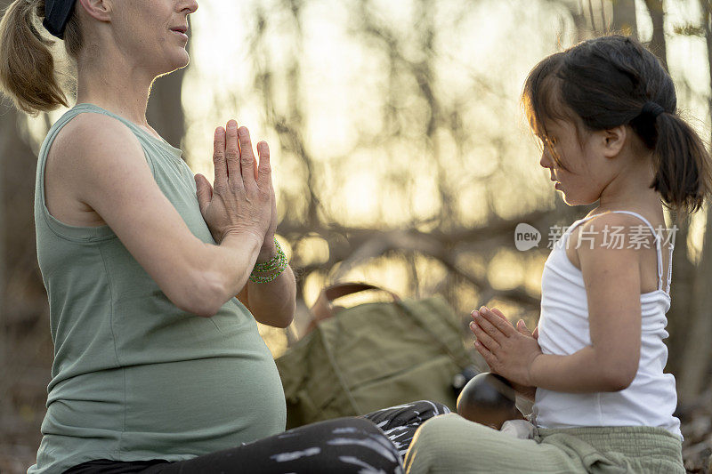 母亲在森林里教小女儿瑜伽