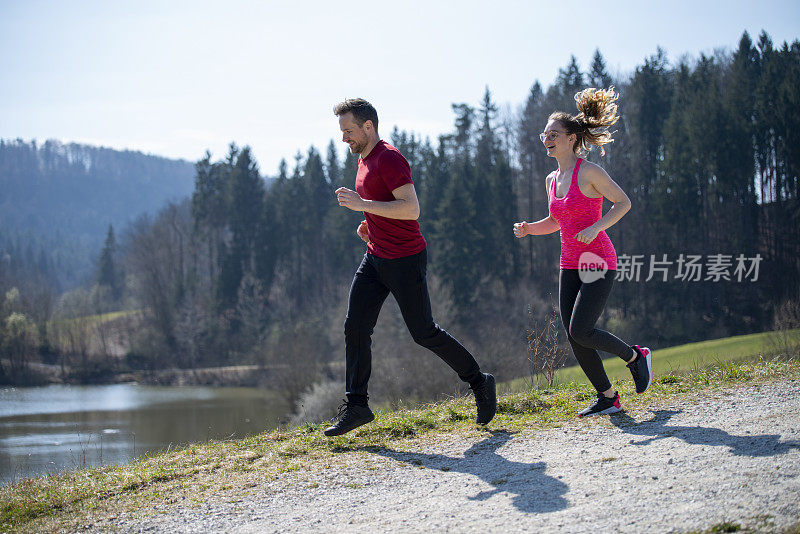 一对年轻夫妇在一个阳光明媚的日子里跑步