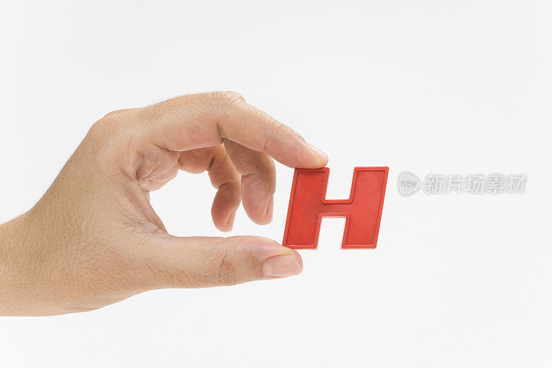 女性手握塑料字母H