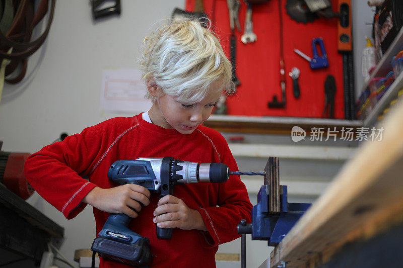 一个和木工工具一起工作的小男孩