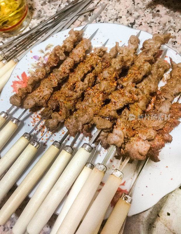 烤肉串。烧烤。中式烤肉，配上香料和蔬菜，以木板为背景