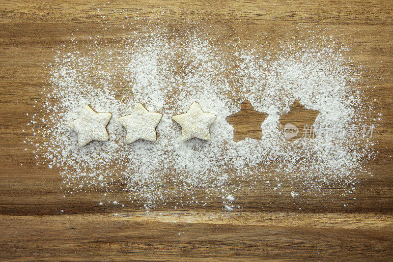 5分中的3分——由糕点星星和糖粉在木质表面上排成一排表示