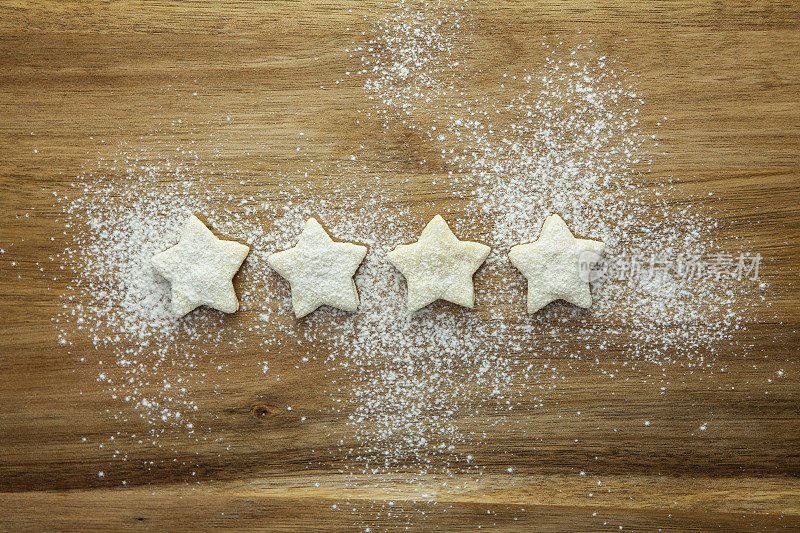 4星评级-由糕点星和在木质表面中间的糖霜表示