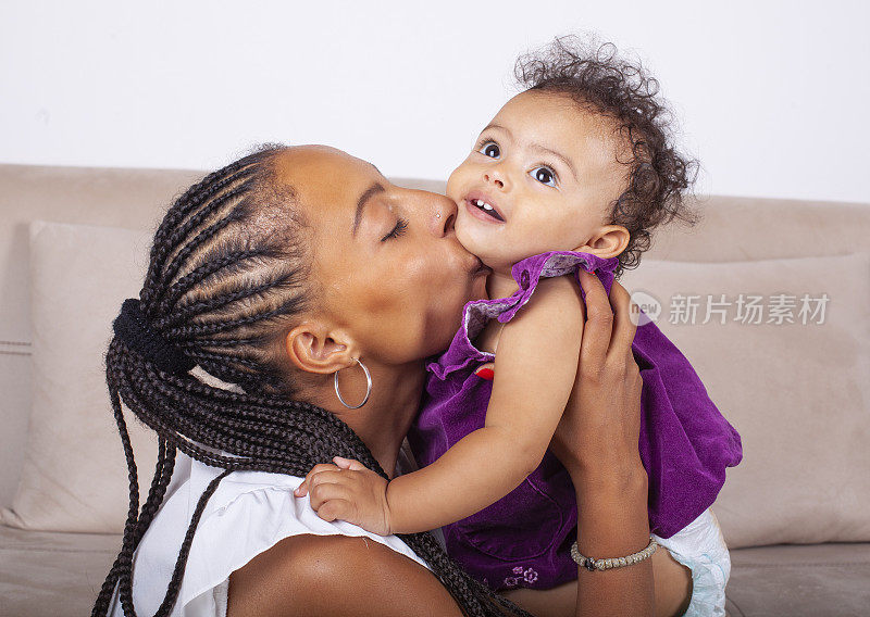 年轻的非洲裔美国妇女亲吻她的小女儿