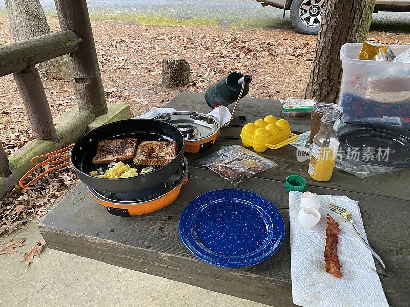 在帐篷里用野营炉烹饪法式吐司、鸡蛋和培根