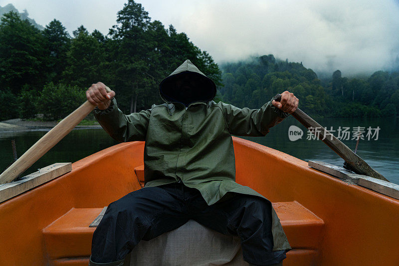 人在湖上钓鱼，从船雨衣船神秘危险