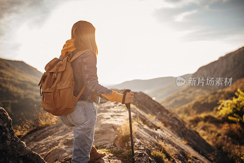 一位女徒步旅行者在欣赏山顶悬崖的景色