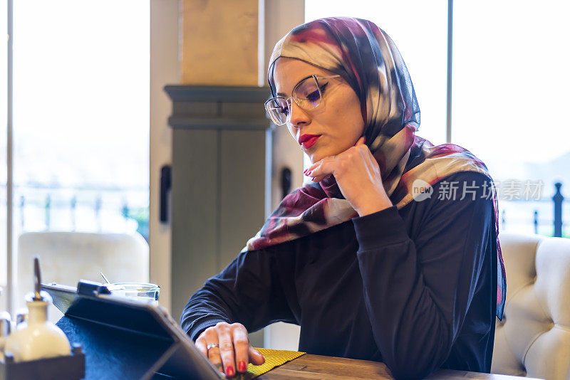 一名穆斯林妇女在餐馆里用药片喝茶