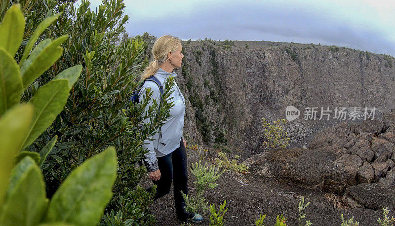 女人沿着火山边缘徒步旅行