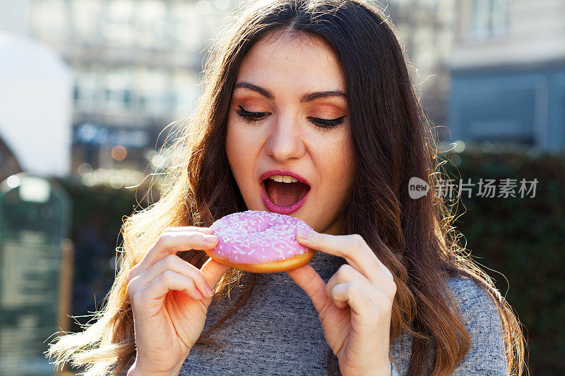 年轻女子在吃甜甜圈