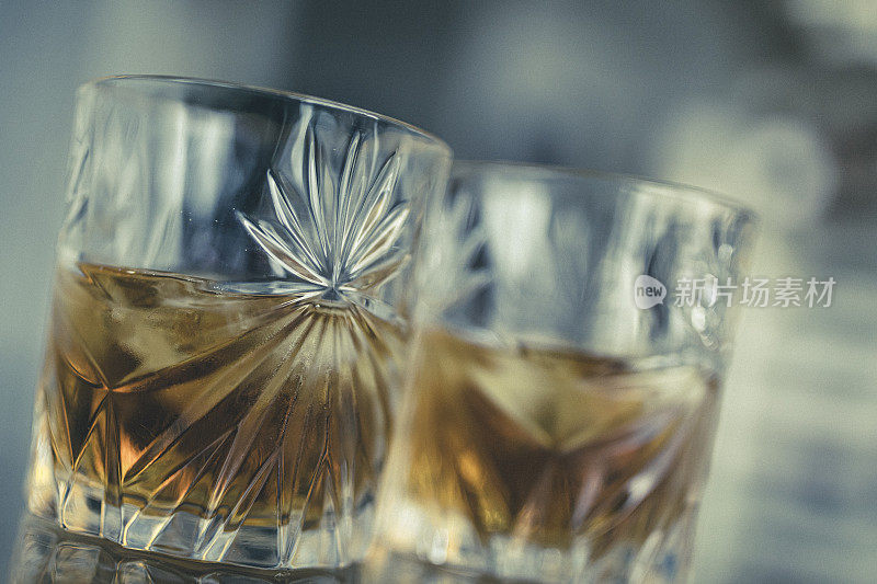 在一张玻璃桌子上，两杯加冰的苏格兰威士忌正等着你品尝。