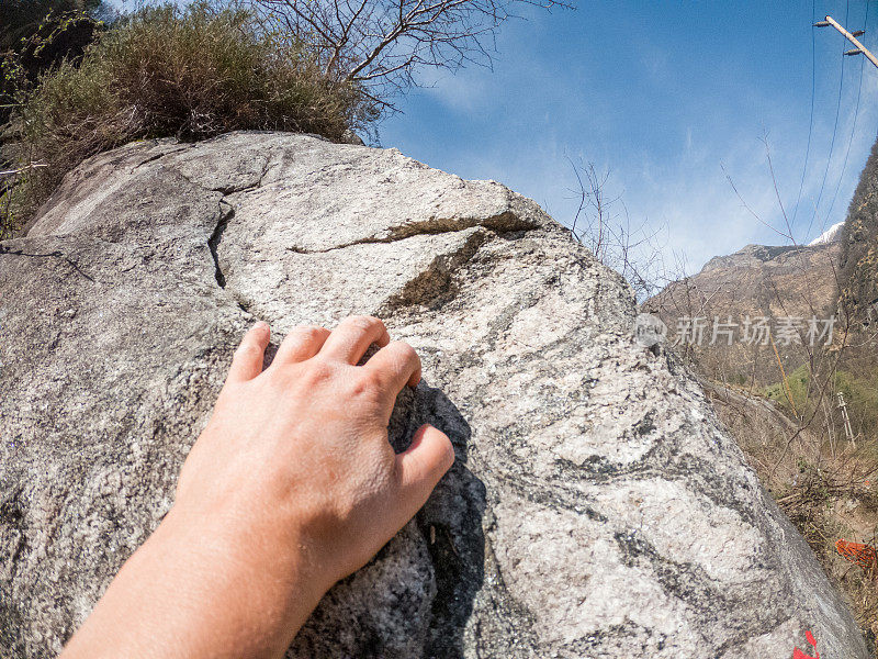 女登山者把手伸向岩石