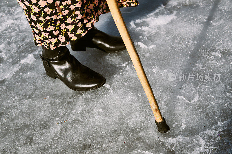 一个女人在冬天走在结冰的街道上。