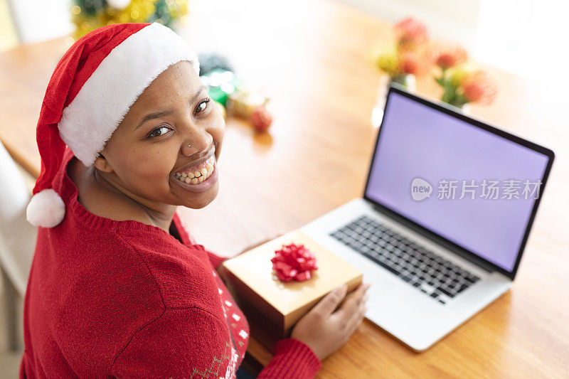 快乐的非洲裔美国人大码女人做圣诞视频通话笔记本电脑与复制空间