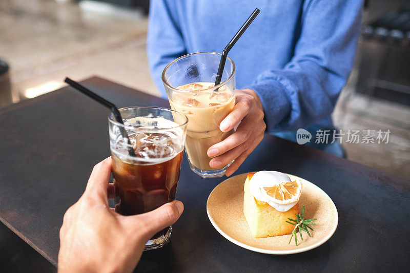 咖啡桌上一对夫妇用柠檬蛋糕碰咖啡杯的特写