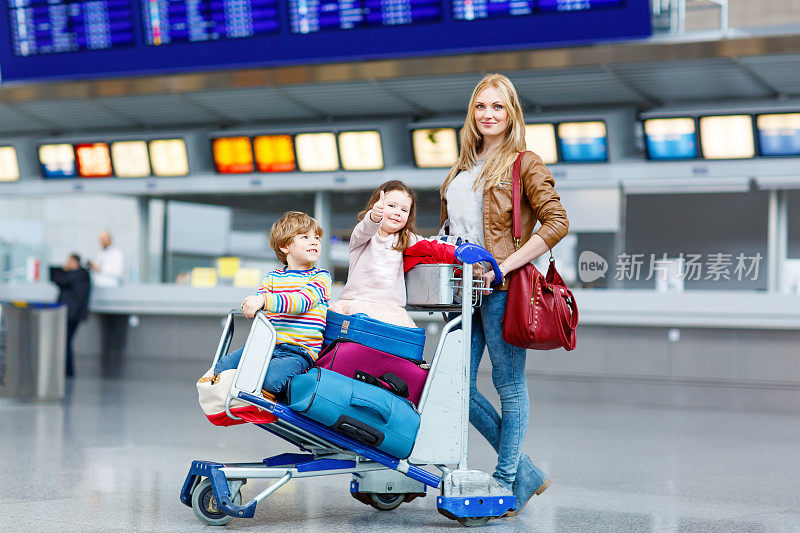 小女孩，小男孩和妈妈带着行李箱在机场