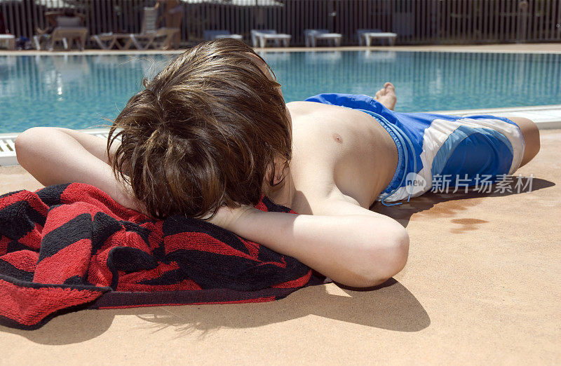 男孩在泳池边休息