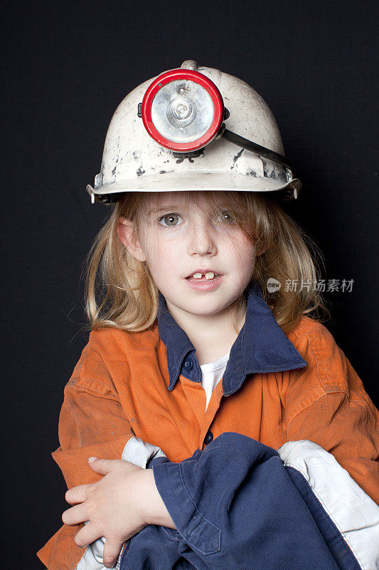 年幼的孩子在煤矿矿工帽和安全服装