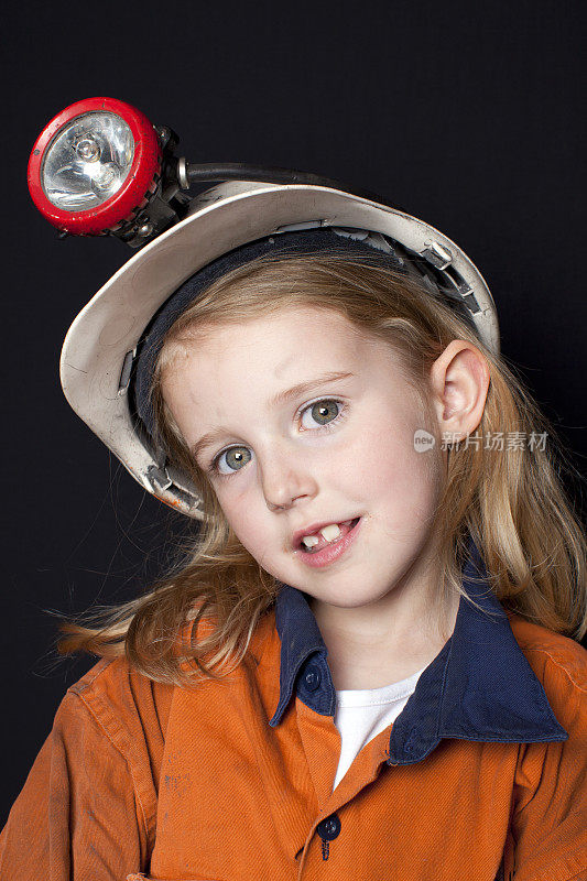 年幼的孩子在煤矿矿工帽和安全服装
