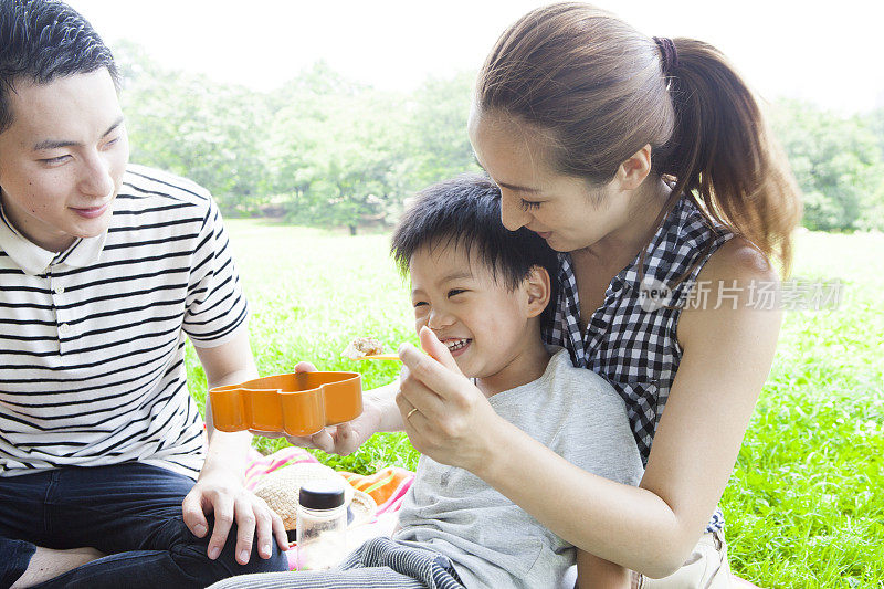 男孩高兴地吃着米饭在公园里